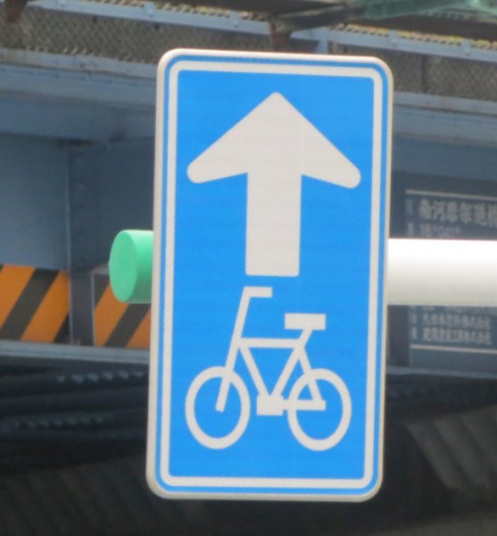  自転車一方通行を表す標識。自転車は矢印の示す方向の通行ができ、逆方向からの通行はできない 
