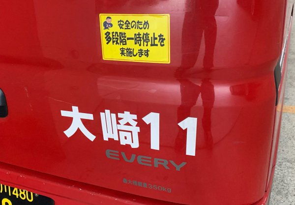 後日、大崎郵便局を訪れ、赤い郵便車に貼られているステッカーを撮影した。郵便局では配送への出発にも左右の指差し確認などともに「多段階一時停止」を行っている