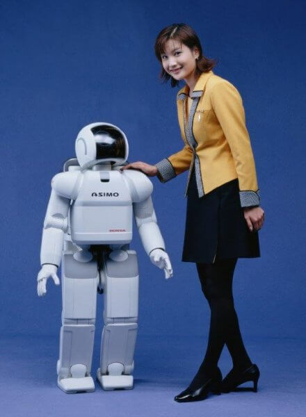 2000年に発表された初代ASIMO（アシモ）。2011年モデルのスペックでは、身長130cm、重量48kg、最大速度9km/hとなっている。成人女性と比較するとご覧のようなサイズ感となる