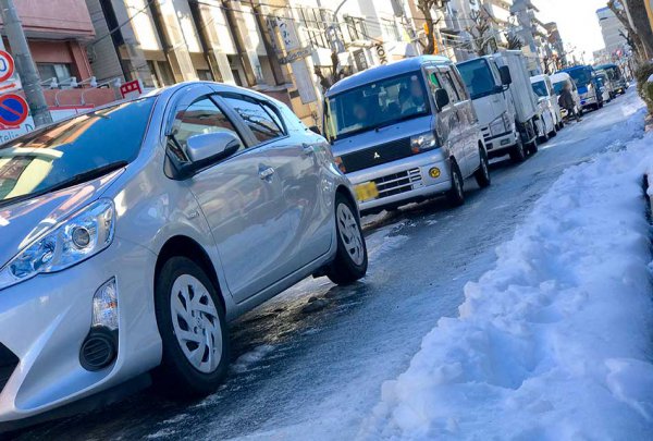 東京23区内。大雪から4日目の朝ビル陰になる路面はツルツルのアイスバーンに磨き上げられていた。スタッドレスタイヤでも慎重な運転が求められる路面である