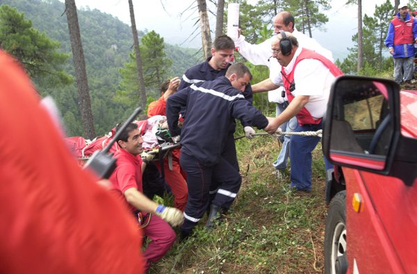 急峻な谷底から担架に乗せられたカメラマンが救出される。ここから病院へと運ぶのは……
