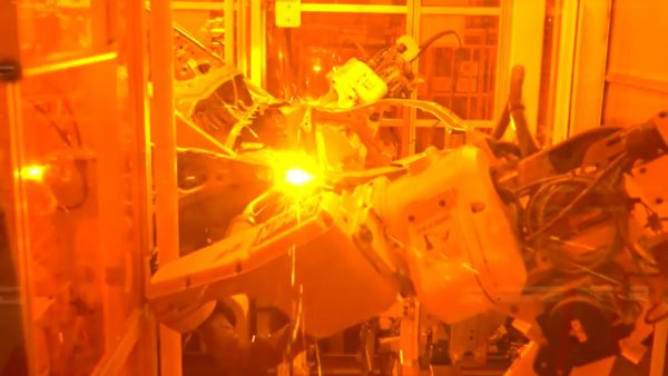 アーク溶接の工程。スポット溶接は天の溶接だがアーク溶接は線の溶接をする工程。鉄板をつなぎ合わせる構造上、部分的にアーク溶接を行うという。溶接作業時に強い火花が発生するため、作業者の目を保護する意味でオレンジ色のアクリル板で囲われ、ロボットがなかで作業をする（出典：スバル）