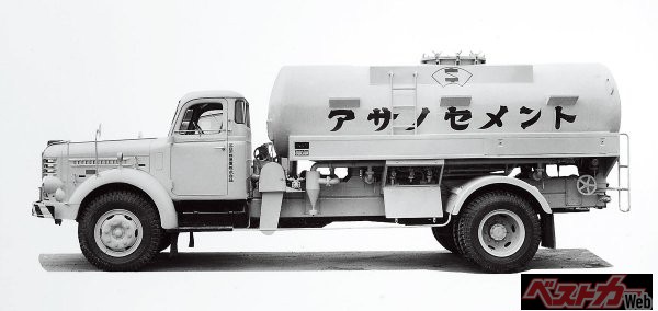 犬塚製作所では、ミキサー車とともに日本初のスクリュー式バラセメント運搬車も開発していた（1951年製作）。当時セメントなどの粉粒体は、紙袋や布袋に入れられ運搬していた。このクルマは、粉粒体のままタンクに収容し、底部に設けたスクリューコンベアで排出できるようにしたバラセメント運搬車の１号車である