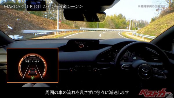 写真はCO-PILOT 2.0を搭載した試験車両で、一般道走行中に異常事態を検知して減速している車内の様子