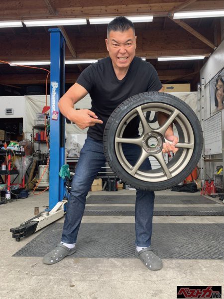純正ホイールに装着したHF805を軽々と持ち上げる小川直也さん。小川さんは、これまで装着していたタイヤに比べて明らかに軽く、ばね下が軽くなると語った