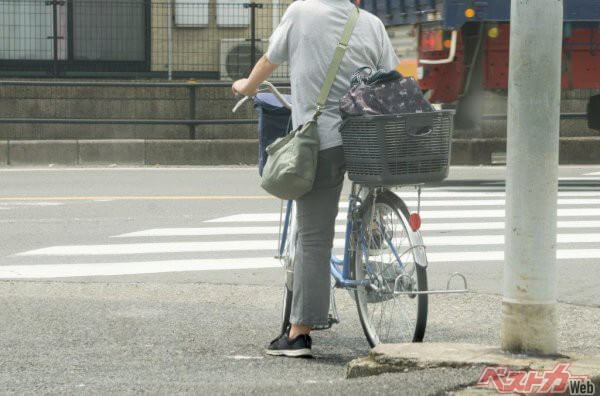 道交法では、横断歩道にはいつでも停止線で止まることができる速度で近づき、歩行者が渡ろうとする意思を見せた場合は停止して譲るとだけ定めている。ただし、写真のように自転車に乗っている場合は軽車両扱いとなり、自転車を降りて押す場合は歩行者扱いに（AdobeStock@xiaosan）