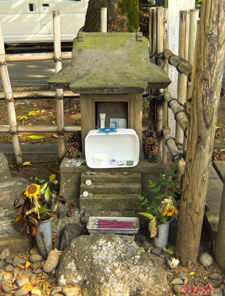 上野博士のお墓の敷地内にちょこんと佇む、この祠がいわゆる忠犬ハチ公のお墓だ！ ハチ公ファンは世界中にいるのか、なぜか世界各国のコインが置いてありました