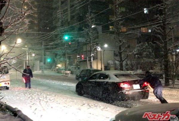 2018年1月22日、都心部で4年ぶりに20cmを超える大雪が降りましたが、その時にサマータイヤを履いたまま走り、坂道で道路を塞ぐクルマが目立ちました。写真はサマータイヤを履いたクルマを警察官が押している様子