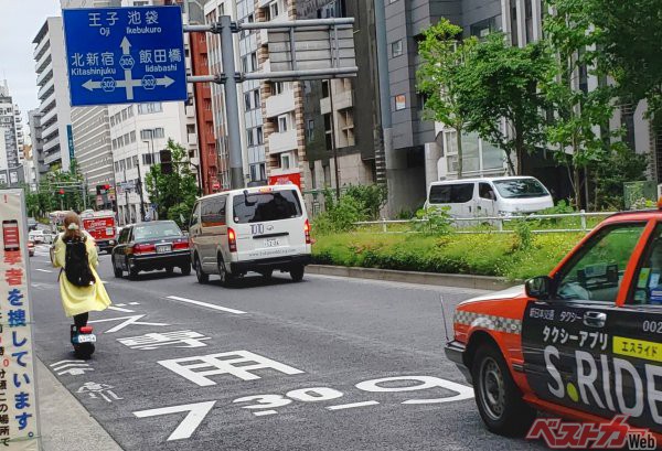 都内を走る電動キックボード。重心が高く、二輪のため、段差では安定性に欠ける。ドライバーやライダーとしては追い抜きの際に気をつかう ※写真は筆者撮影<br>