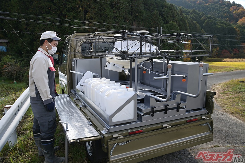 ダイハツ農薬散布ドローンシステム。人力だと2時間ほどかかる農薬散布が2分で可能。テスト的に有償でのサービスも開始した。軽トラに積載、運用までをワンオペできるよう改良・開発中。一機あたりの価格は350万円!