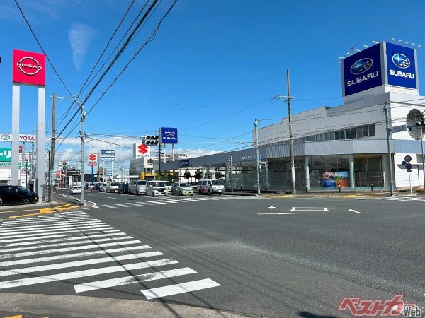 和田西交差点の様子。スバル、日産、スズキ、トヨタ、ホンダの看板が見える<br>