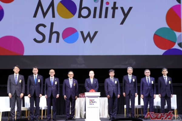 皇族の瑤子女王と、その左に豊田章男会長、左右には自工会副会長である各自動車メーカーの社長たちがずらりと並び、ジャパンモビリティショー開会の「スイッチオンイベント」が実施された