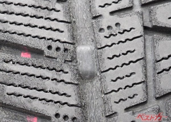 タイヤとしての摩耗限界を示すスリップサイン。写真のタイヤはスリップサインが左右のタイヤ溝と同じ高さまで来ており、もう限界だ（Adobe Stock@kumi）