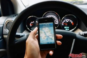 クルマを運転中に信号待ちでスマホをいじるのはやっぱりダメ？　走行中の車内でハンドルを握りながらおにぎり食べると捕まるってマジか!?