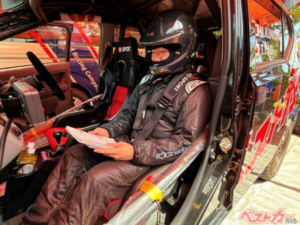 レーシングスーツにヘルメットを装着し、ペースノートを読む練習を繰り返す矢尾さん