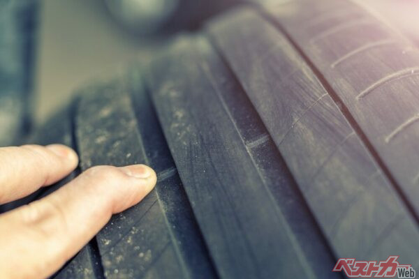 タイヤ側面にある△マークや記号の延長線上のタイヤの溝の底にある盛り上がった部分の高さをみて、摩耗度合いを判断するのがウェアインジケーター（スリップサイン）（PHOTO：Adobe Stock_Kirill Gorlov）