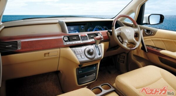 左右を貫く木目パネルがドライバーと助手席乗員の空間的一体感を強調。メーターフードを排したフラットな上面形状によって、広がりある視界と先進的な印象を両立させている