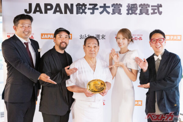 トロフィーを手にする『餃子の店 您好』 店主の野坂由郎さん。写真左から、審査員の小野寺 力さん、オガサワラガクさん。 「JAPAN餃子大賞」初代アンバサダー・元日向坂46キャプテン、佐々木久美さん。審査員のクック井上。さん