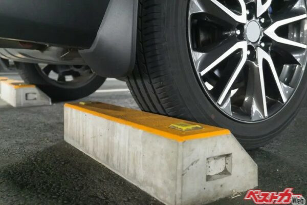クルマ止めにタイヤを強く押し付けている状態は、クルマを痛めつける行為。一度クルマ止めに当てたあと、少しだけ前進してクルマ止めからわずかに離そう（PHOTO：Adobe Stock＠xiaosan）