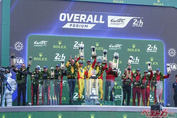 表彰台の真ん中でトロフィーを掲げるクビサ