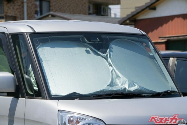 暑い季節に屋外駐車場で使用している車を多数見かけるサンシェード。その効果のほどは……？（xiaosan＠AdobeStock）