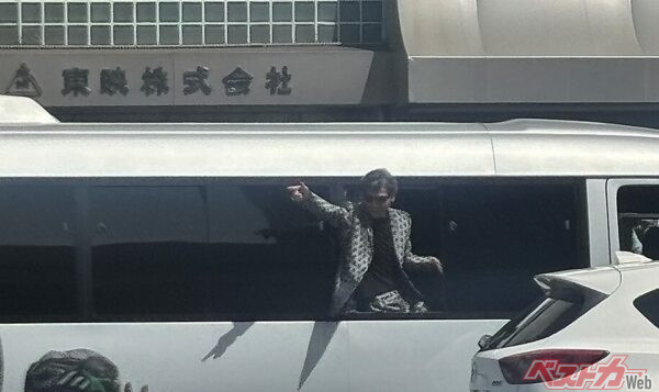 停車中のロケバスから銃を撃つポーズをとる柴田さん。反対側の沿道にも多くのファンが駆け付けました。「ユージ!撃って~」の声にこたえています