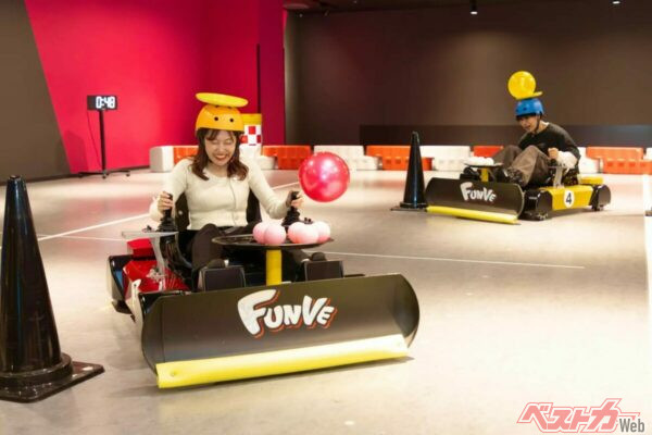 プレイヤーが頭上と足元にボールを乗せた状態で、スラロームコースを走行するバランスゲーム