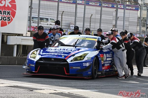 日産メカニックチャレンジをサポートする日産ディーラーの整備士、そして日産自動車大学校の学生が車検場に56号車を運ぶ