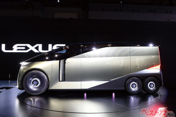 大きなスライドドアを閉じると、ドアの向こうから現れたのは小径2軸の後輪。前輪1軸＆後輪2軸の6輪ミニバンだ