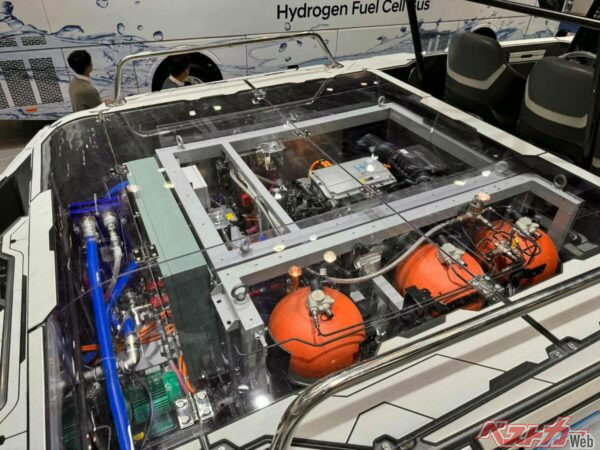 オレンジの水素タンクが積まれた車両。となりには水素バスが見える