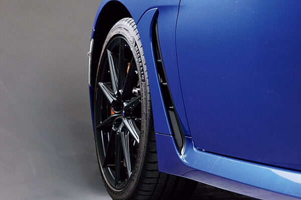 空力パッケージは単に空気抵抗の低減だけを目的としていない。ホイールハウス内で発生する空気乱流を防ぐフロントエアアウトレットなどを採用し、ピュアスポーツカーらしい高速域での直線安定性と安定感のある旋回性を実現している