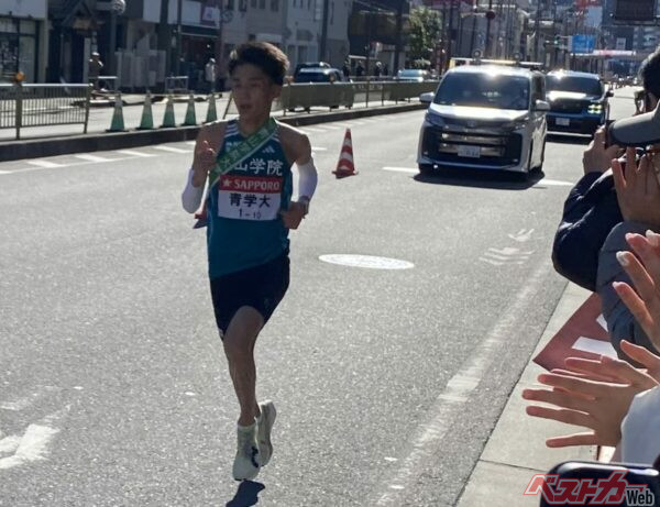 快足を飛ばす青山学院大学・10区の選手。後方、ノアの後ろに迫るクルマはいったい……!?