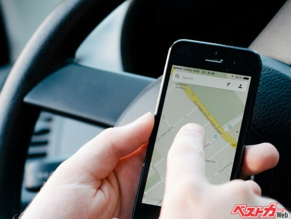 カーナビがわりにスマホを使用している人を見かけるが、これは非常に危険！　完全に「注視」に当てはまる（写真AC）