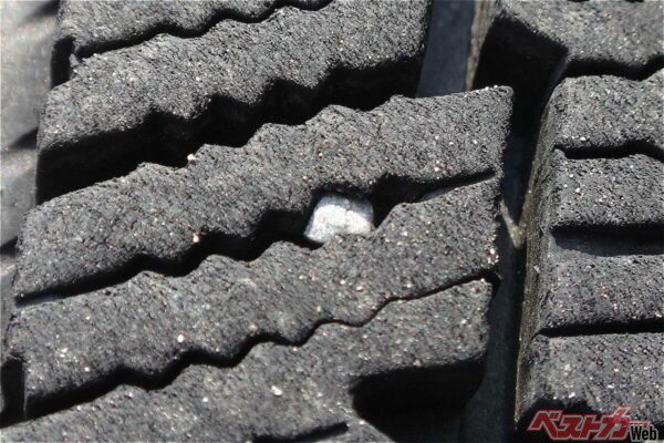 タイヤの溝に挟まった小石。サイプが荷重でたわんでどんどん奥に入ってしまう（写真AC）