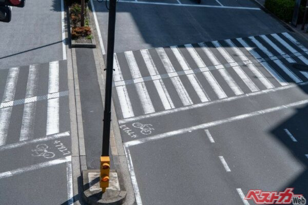 写真のように横断歩道に自転車横断帯がある場合、自転車は指定場所以外は走行できないが、クルマやバイクはこの場合、自転車の走行を妨げてはならない(Hassyoudo@AdobeStock)