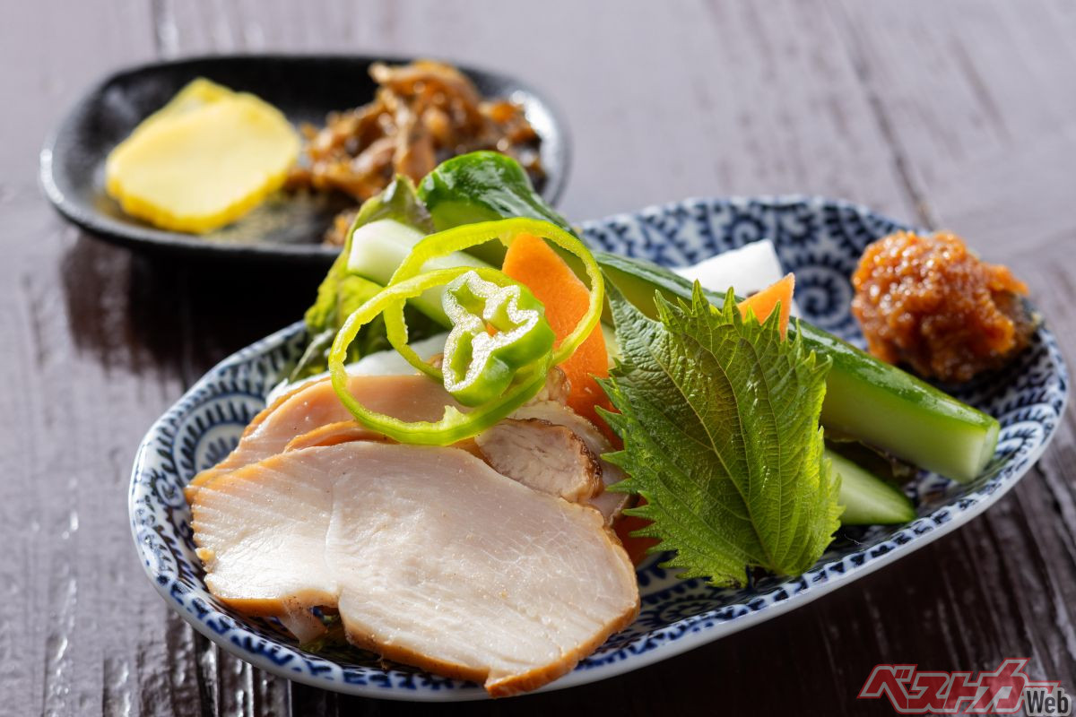 『手打そば　やまびこ』お客全員に出されるサービス品。近隣で採れた野菜＆自家製の鶏の燻製（手前）と漬物2種（奥）