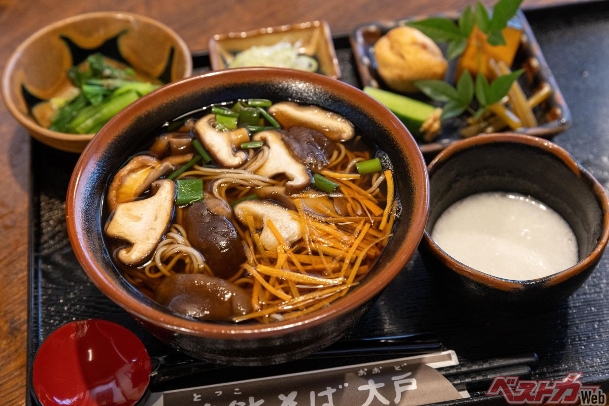 『独鈷そば大戸』「独鈷かけそば」（1470円）。たっぷりのしいたけと刻んだにんじんの入った蕎麦に小皿、小鉢、とろろなどがついてくる