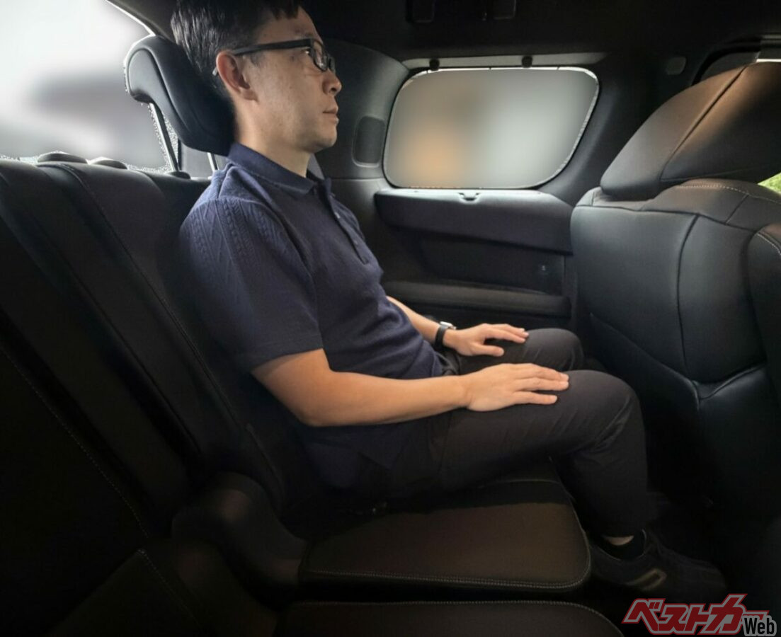 同じ条件で3列目に座った全身の姿勢。足を前へ伸ばせず、膝が持ち上がる。助手席と2列目でオットマンを使うときは、3列目の座り方にも影響が出る