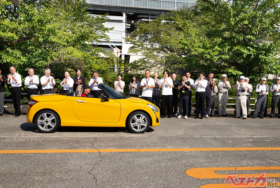 工場内の道路を移動する最終生産車。沿道ではダイハツ社員が拍手で見送った