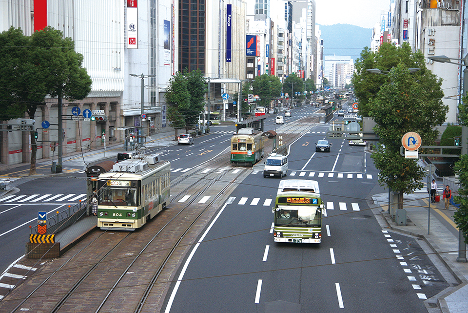 広島市の中心市街地・八丁堀も早朝はまだ人影がまばら。早起きな人々を乗せた広電のバスと路面電車が並走しながら広島駅を目指す