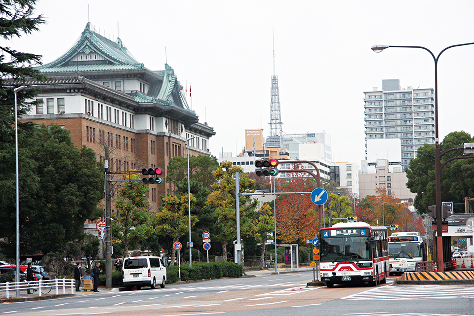 愛知県庁本庁舎と名古屋テレビ塔をバックに走る基幹バス。中央走行方式のバスレーンを名鉄バスと名古屋市営バスが共用している