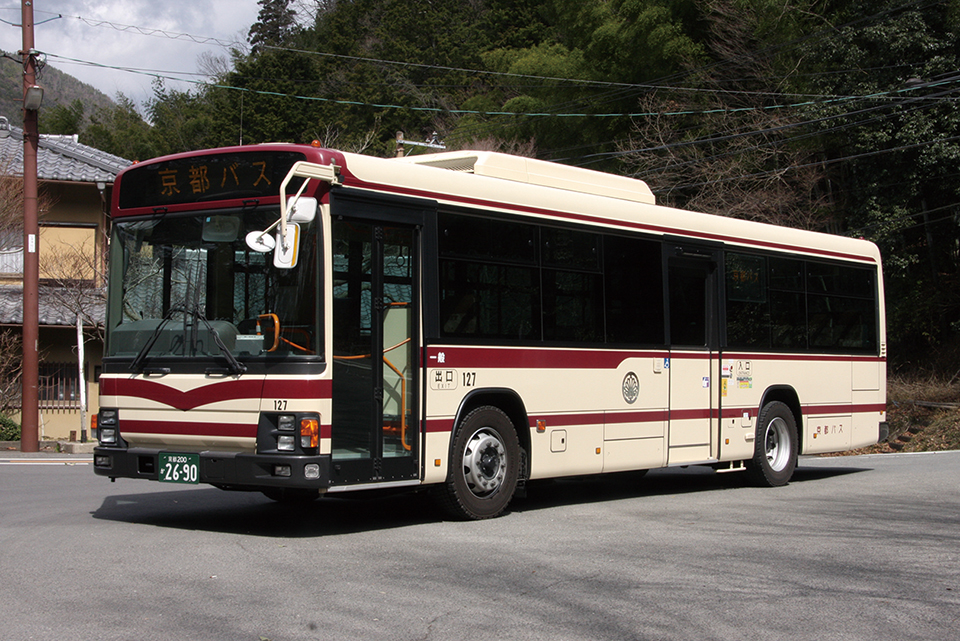いすゞ QPG-LV234N3　■127／京都200か2690　嵐山営業所／一般路線　2013年式のいすゞエルガワンステップバスで、QPG-の本型式は1台のみ。1997年から増備されてきた大型ワンステップバスの最後の1台となった。クリームにマルーンの帯という路線車カラーは福井の京福バスと同一だが、京都バスの側面には鞍馬自動車から引き継いだ社紋が掲げられている