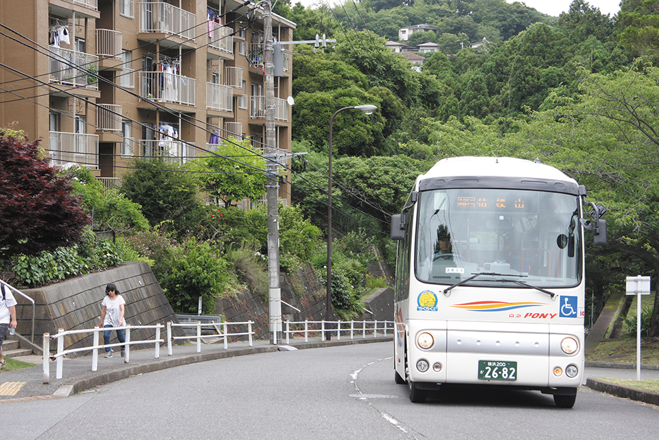 桔梗山の住宅地を行く「京急ポニー号」。デマンドルートを持つこの路線は、夜行高速バスと同じカラーの小型バスによって運行される