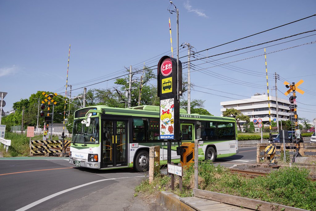 JR八高線東飯能駅近くの踏切を、国際興業バスの大型路線車が渡る