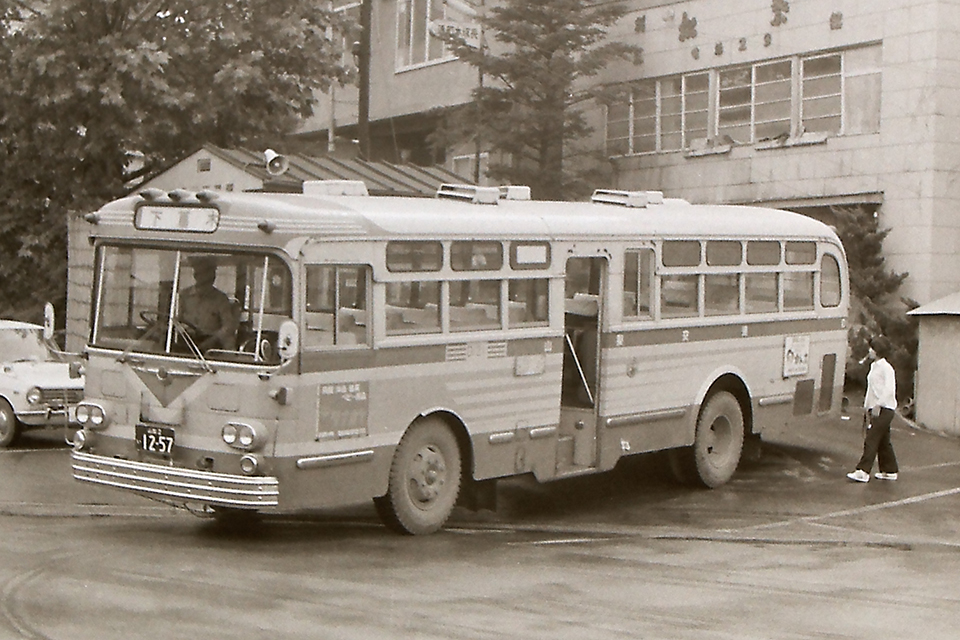 終点の駅前に到着し、車掌のバック誘導で乗り場に着け、待機する山梨交通の中扉路線バス（1974年）