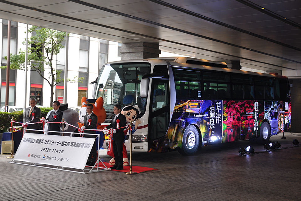 草津温泉のキャラクターと相鉄の「そうにゃん」、東急バスの「ノッテちゃん」とともに上田バスのラッピングバスの前でテープカットし横浜～軽井沢・草津温泉間高速バスがスタート