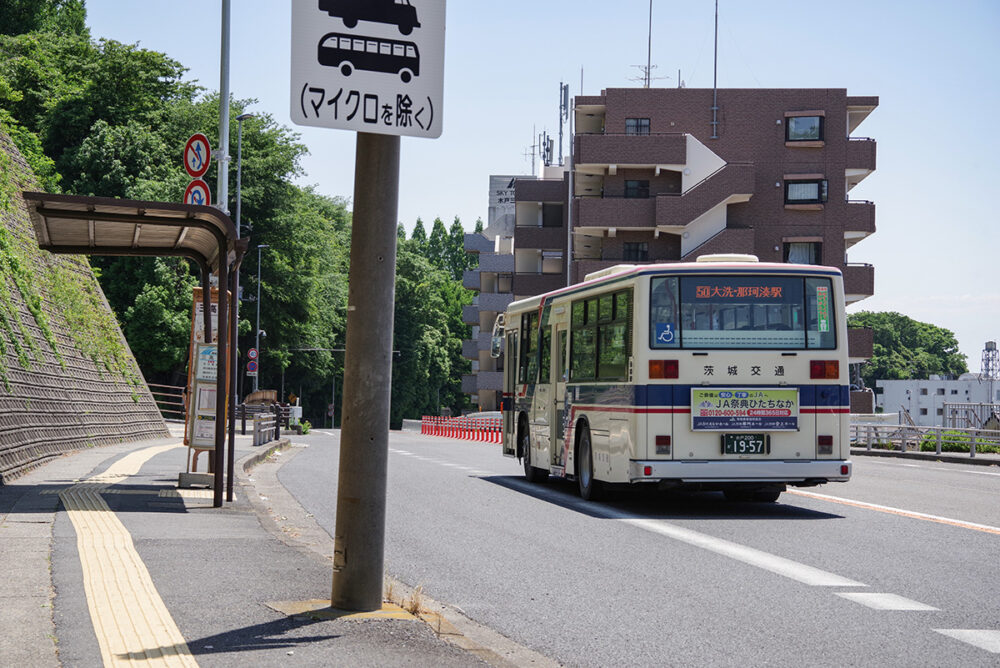三高下バス停を茨城交通の日産ディーゼル＋西工車体の路線車が通過
