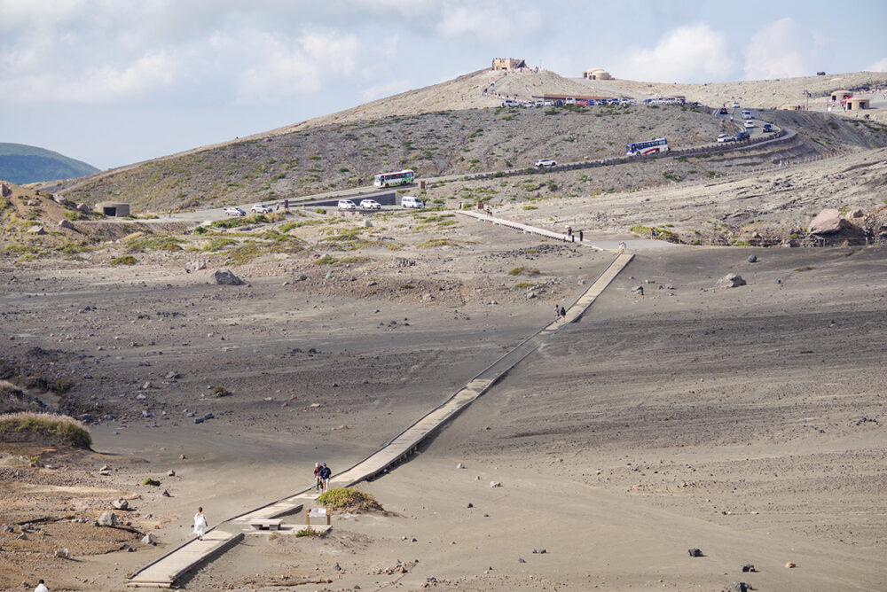 火口周辺も歩いて回れる。奥には山上ターミナルへと向かう続行運転の火口シャトルが