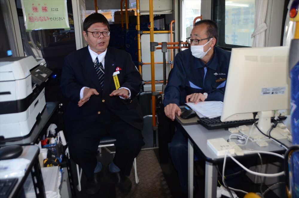 教官から車内で講評を聞き質問をする記者