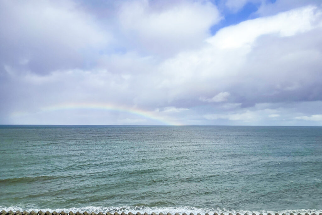 海の向こうに虹がアーチを掛けていた